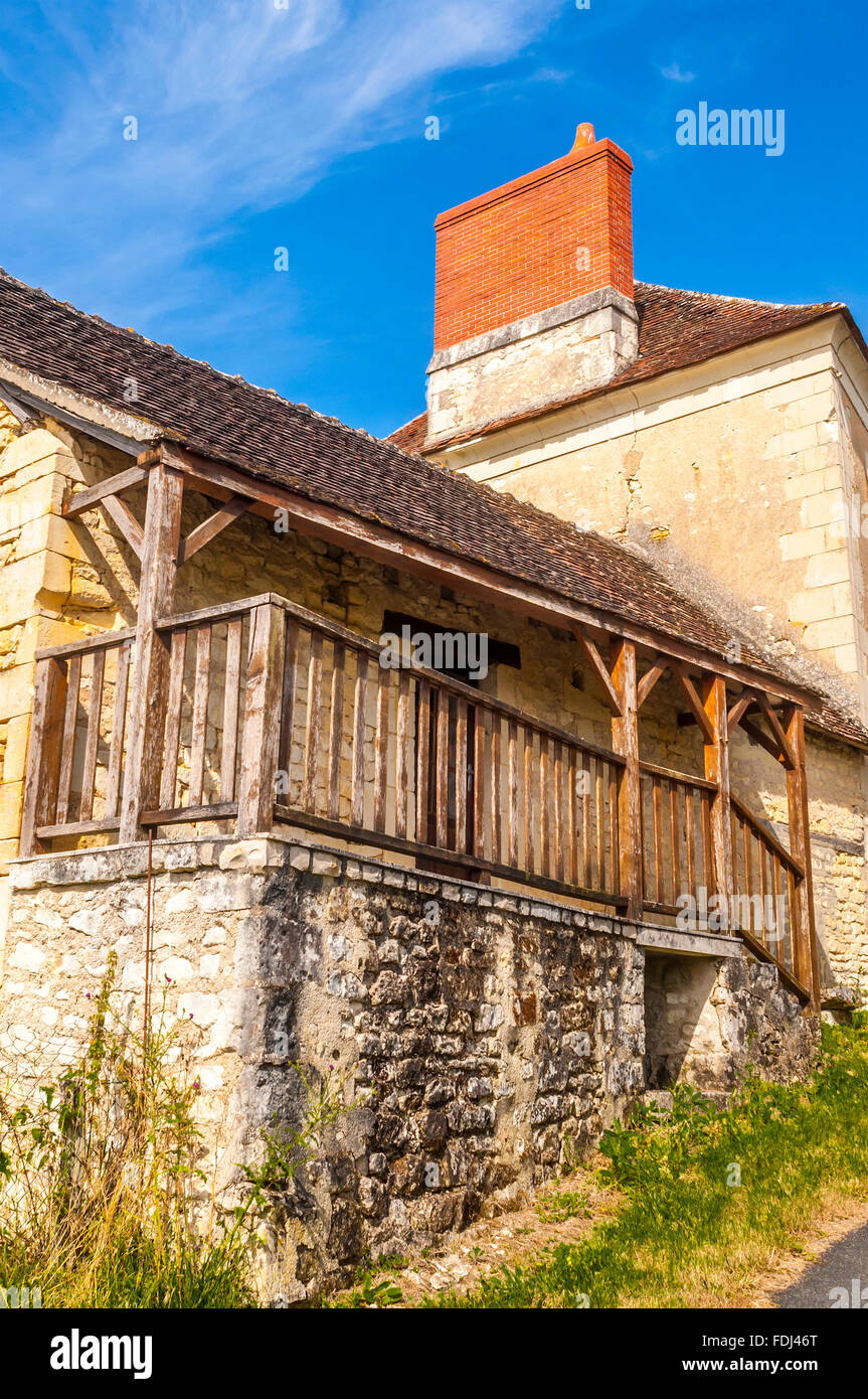 Traditionelles altes Steinhaus mit überdachten Balkon und neue Schornstein - Frankreich. Stockfoto