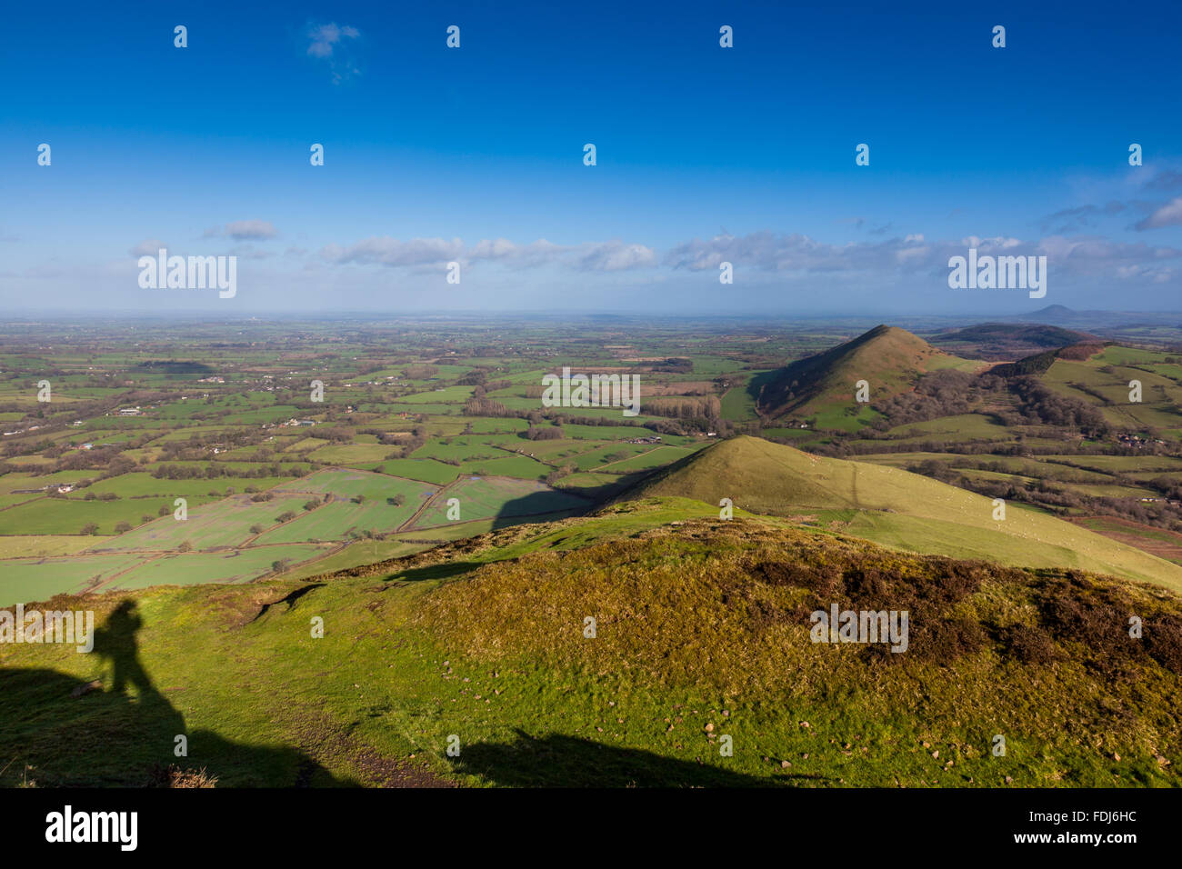 Ein Fotograf, der Schatten auf dem Gipfel des Caer Caradoc mit Blick auf kleine Caradoc, The Lawley und The Wrekin, Shropshire Stockfoto