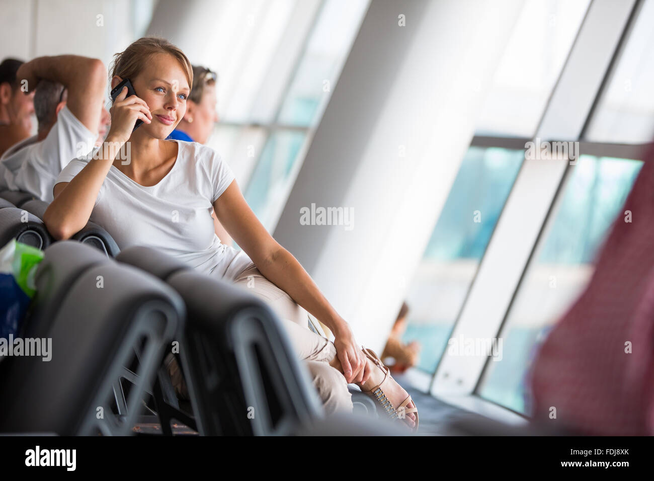 Junge Beifahrerin am Flughafen, etwa zum Check-in, Ausgaben letzten Momente vor dem Einsteigen an Bord in das Telefon mit ihrem f Stockfoto