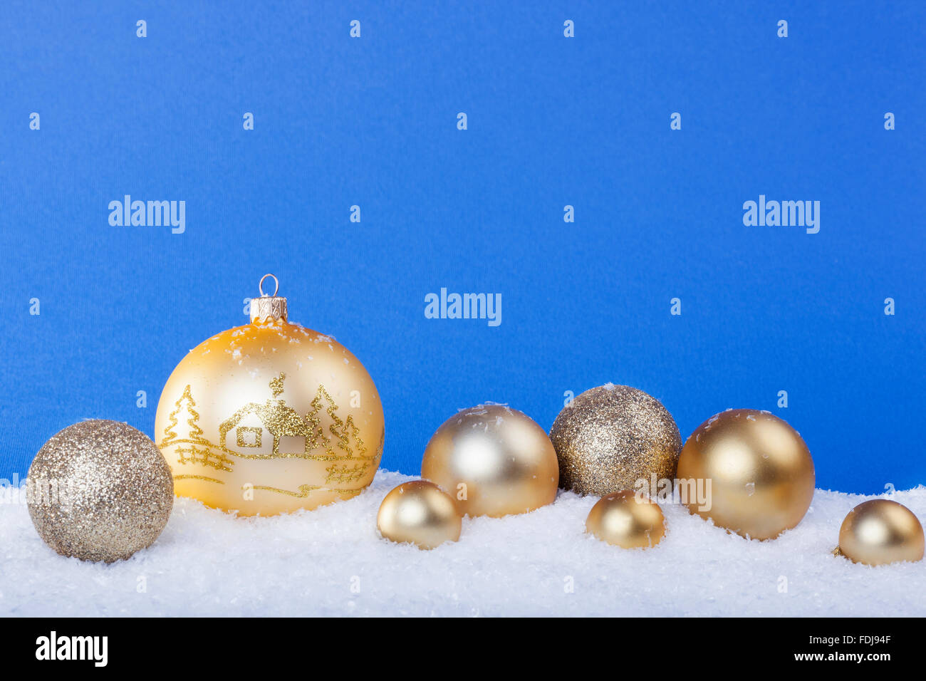 Goldene Weihnachtskugeln im Schnee Stockfoto