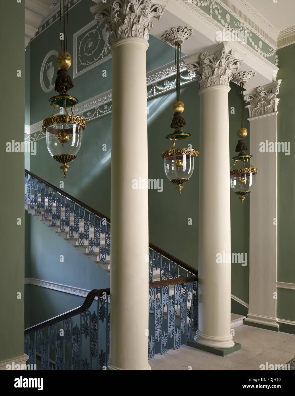 Ein Blick durch die korinthischen Säulen auf der Beletage die große Treppe, entworfen von Robert Adam Osterley Park, Middlesex. Die drei Glas Laternen enthalten Öllampen. Stockfoto