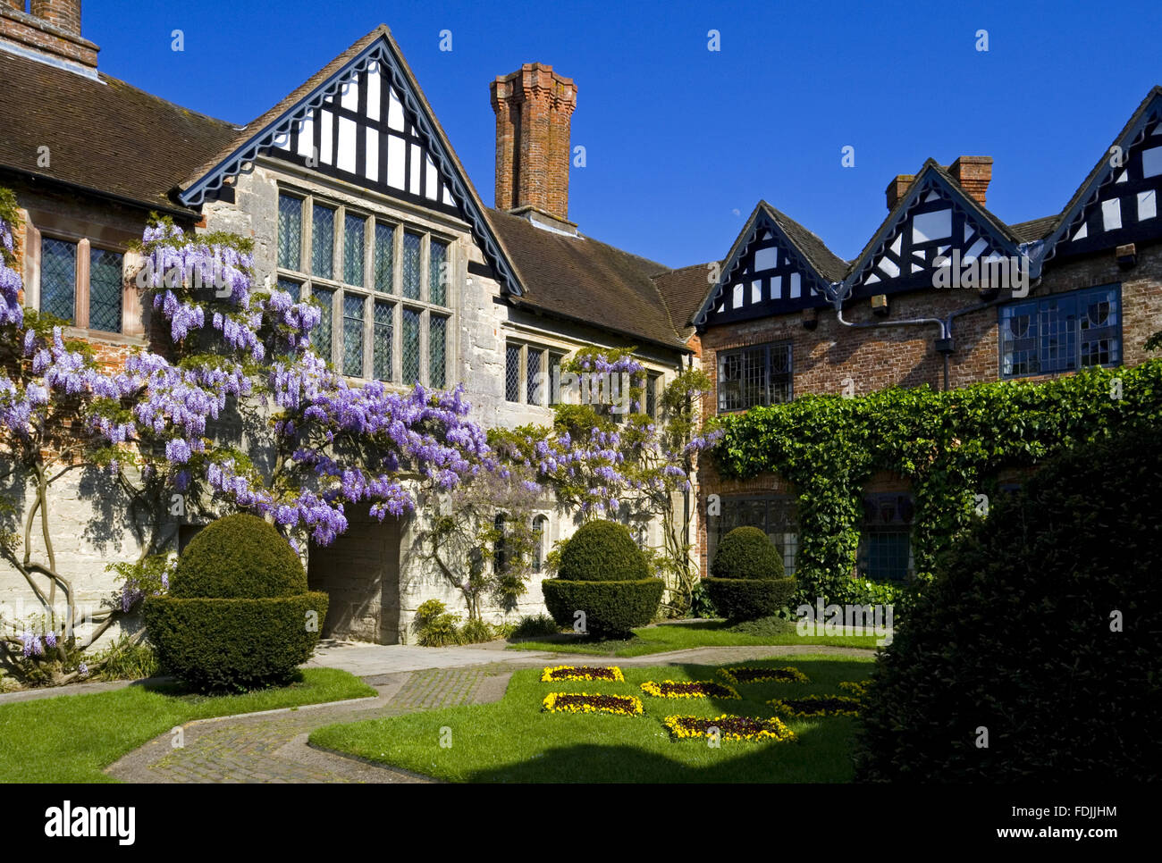 Der Hof in Baddesley Clinton, Warwickshire, mit Blick auf das Torhaus Reichweite und herrliche große Stube Fenster. Garten im Innenhof entstand im Jahr 1889 durch Edward Heneage Dering. Stockfoto
