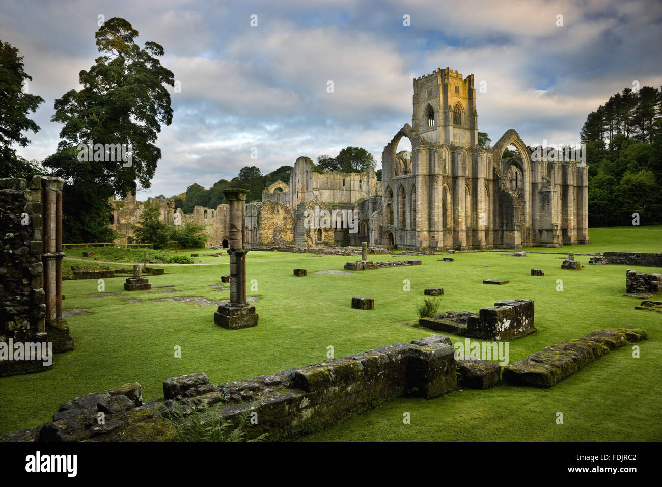 Ein Blick in Richtung Ostende der Abteikirche zeigt die große Osten Fensterbogen im Fountains Abbey, North Yorkshire. Reste von den Mönchen Krankenstation sind sichtbar im Vordergrund. Die Zisterzienser-Gemeinschaft der Mönche wurde hier 1132 gegründet aber war Beiträge Stockfoto