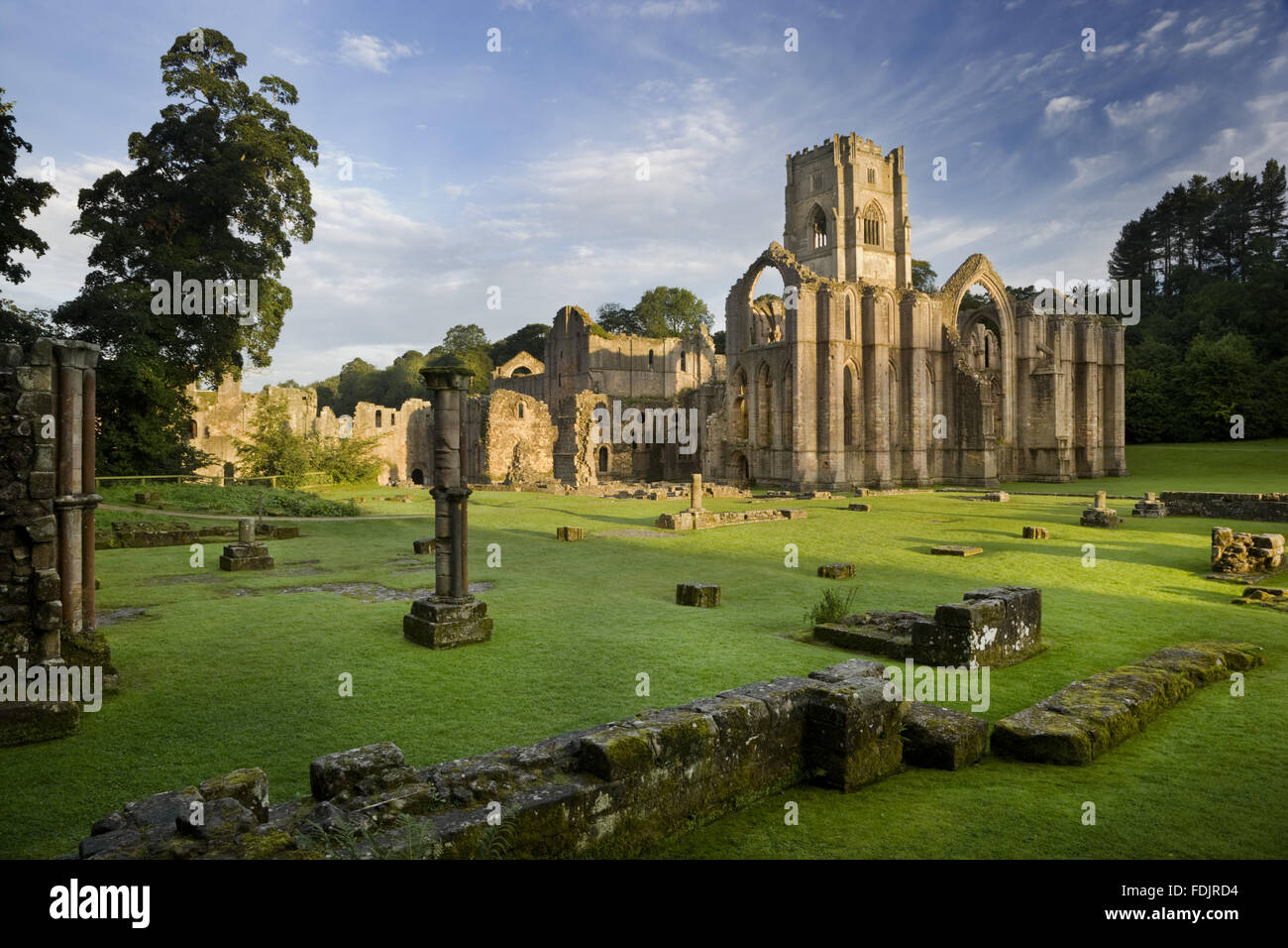 Ein Blick in Richtung Ostende der Abteikirche zeigt die große Osten Fensterbogen im Fountains Abbey, North Yorkshire. Reste von den Mönchen Krankenstation sind sichtbar im Vordergrund. Die Zisterzienser-Gemeinschaft der Mönche wurde hier 1132 gegründet aber war Beiträge Stockfoto