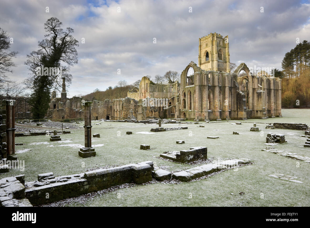 Ein Winter-Blick in Richtung Ostende der Abteikirche zeigt die große Osten Fensterbogen im Fountains Abbey, North Yorkshire. Reste von den Mönchen Krankenstation sind sichtbar im Vordergrund. Die Zisterzienser-Gemeinschaft der Mönche wurde 1132 aber wa hier gegründet. Stockfoto