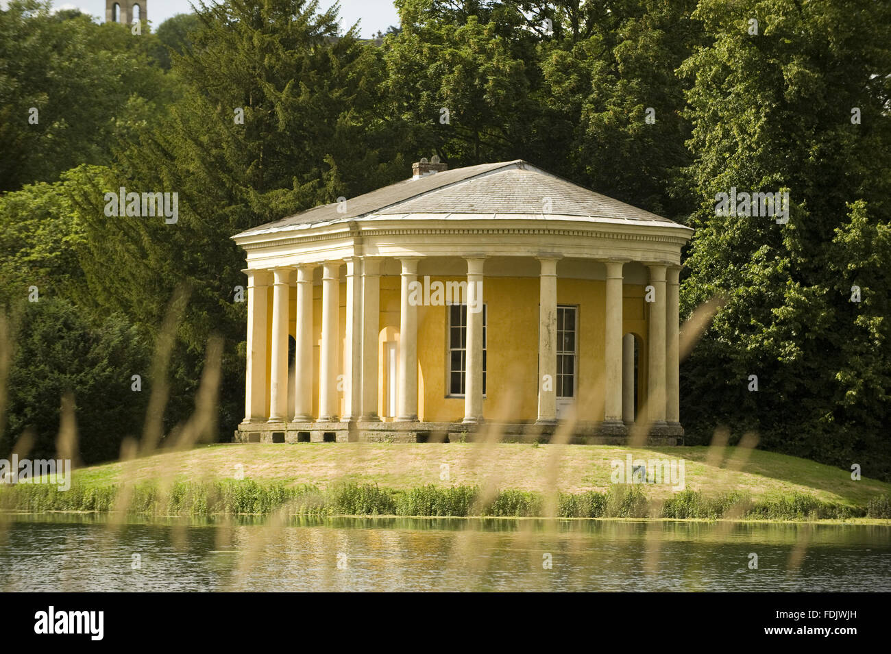 Der Musik-Tempel auf einer Insel im See im West Wycombe Park, Buckinghamshire. Der Tempel hat eine dorische Kolonnade und wurde von Nicholas Revett in den 1770er Jahren entworfen. Stockfoto