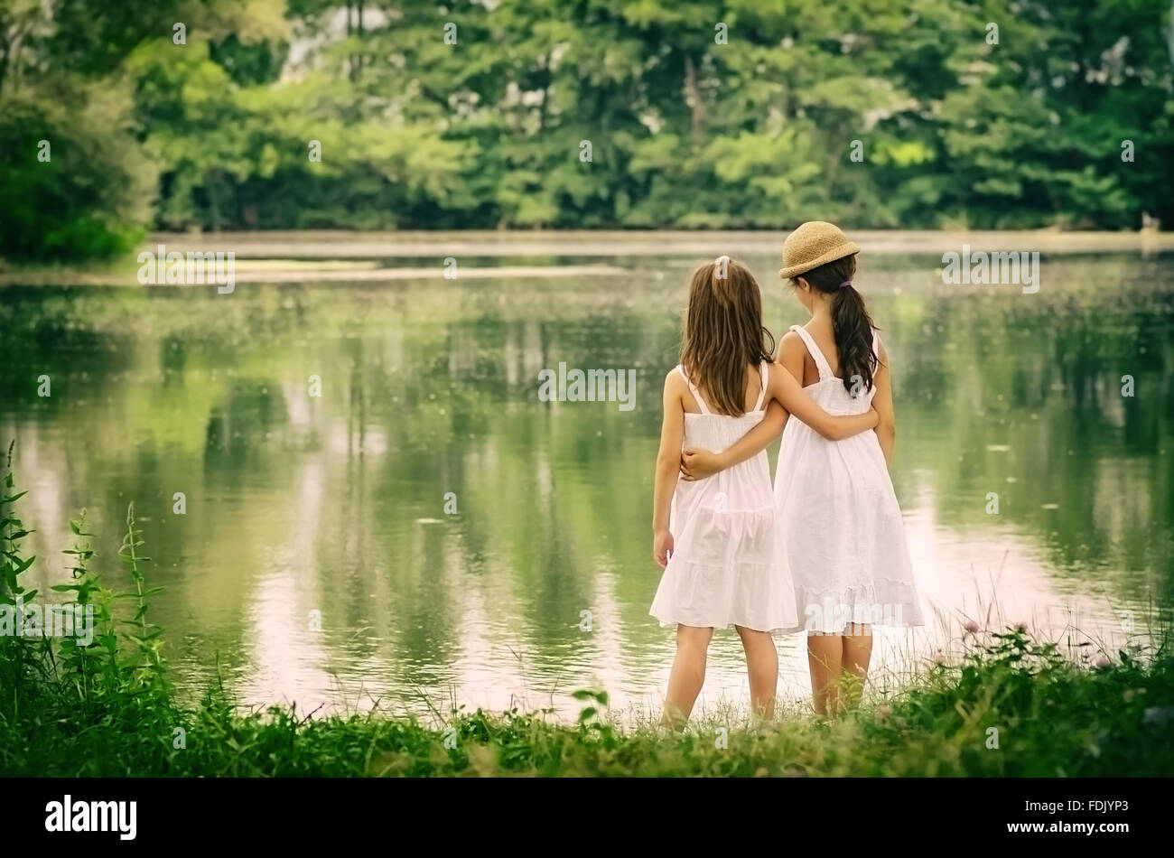 Zwei Mädchen stehen durch die Fokussierung auf Fluss Stockfoto