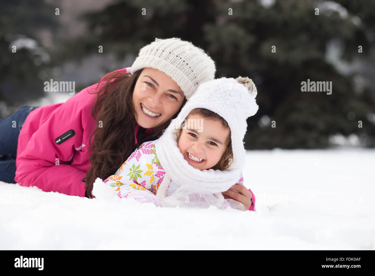 Glückliche Mutter und Tochter im Schnee liegen Stockfoto