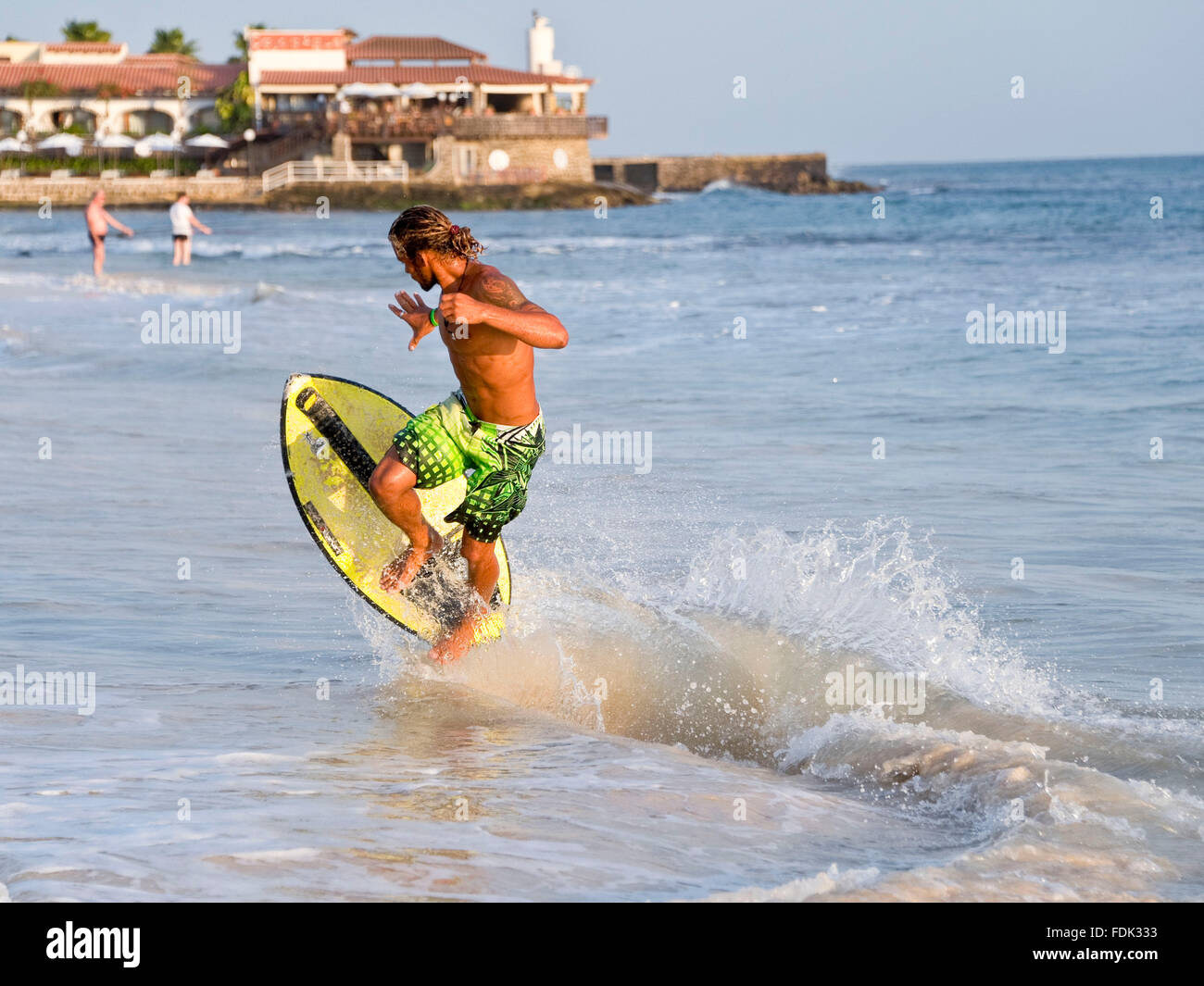 Ein Skimboarder führt einen Trick am Strand von Santa Maria, Insel Sal, Kapverden. Stockfoto