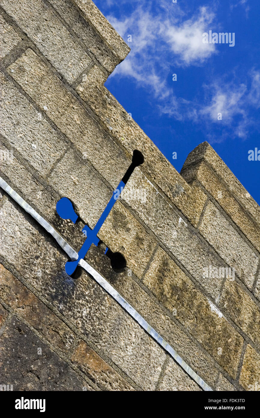 Eine dekorative Pfeil Schlitz auf der zinnenbekrönten Dachlinie des Castle Drogo, Devon. Das Gebäude wurde von Edwin Lutyens entworfen und zwischen 1910 und 1925 gebaut. Stockfoto