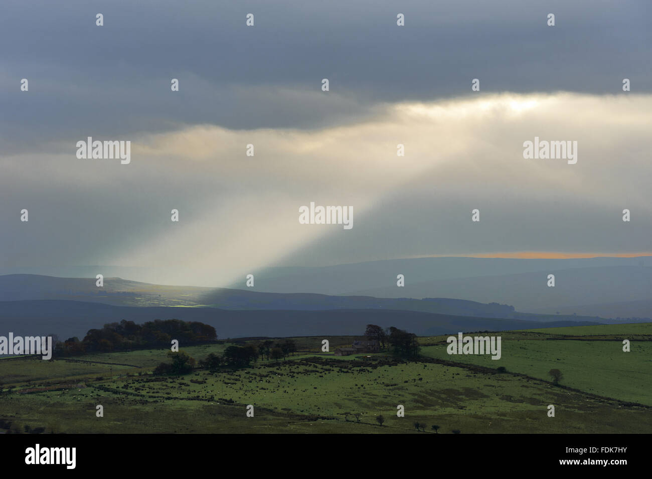 Sonnenstrahlen durch die Wolken am Hadrianswall, Northumberland erscheinen. Stockfoto