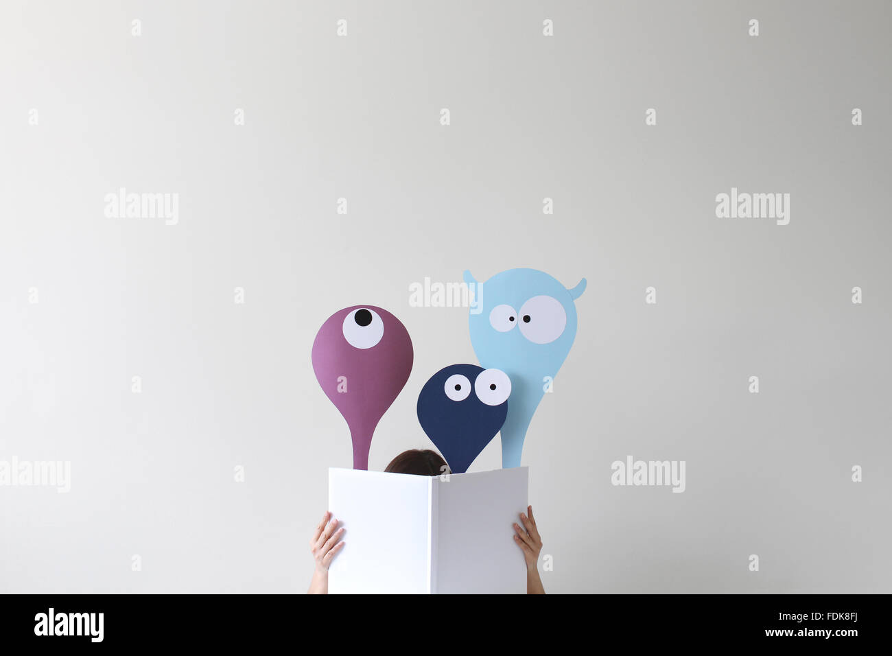 Frau Buch mit freundlichen Monster auftauchen Stockfoto