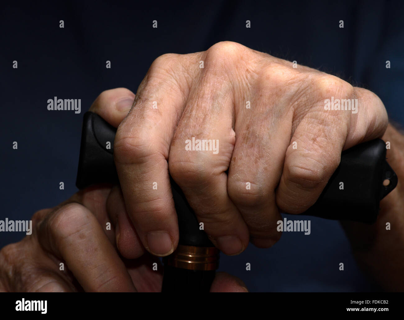 Händen von einer älteren Frau mit chronischen gesundheitlichen und medizinischen Themen greifen einen Gehstock. Stockfoto