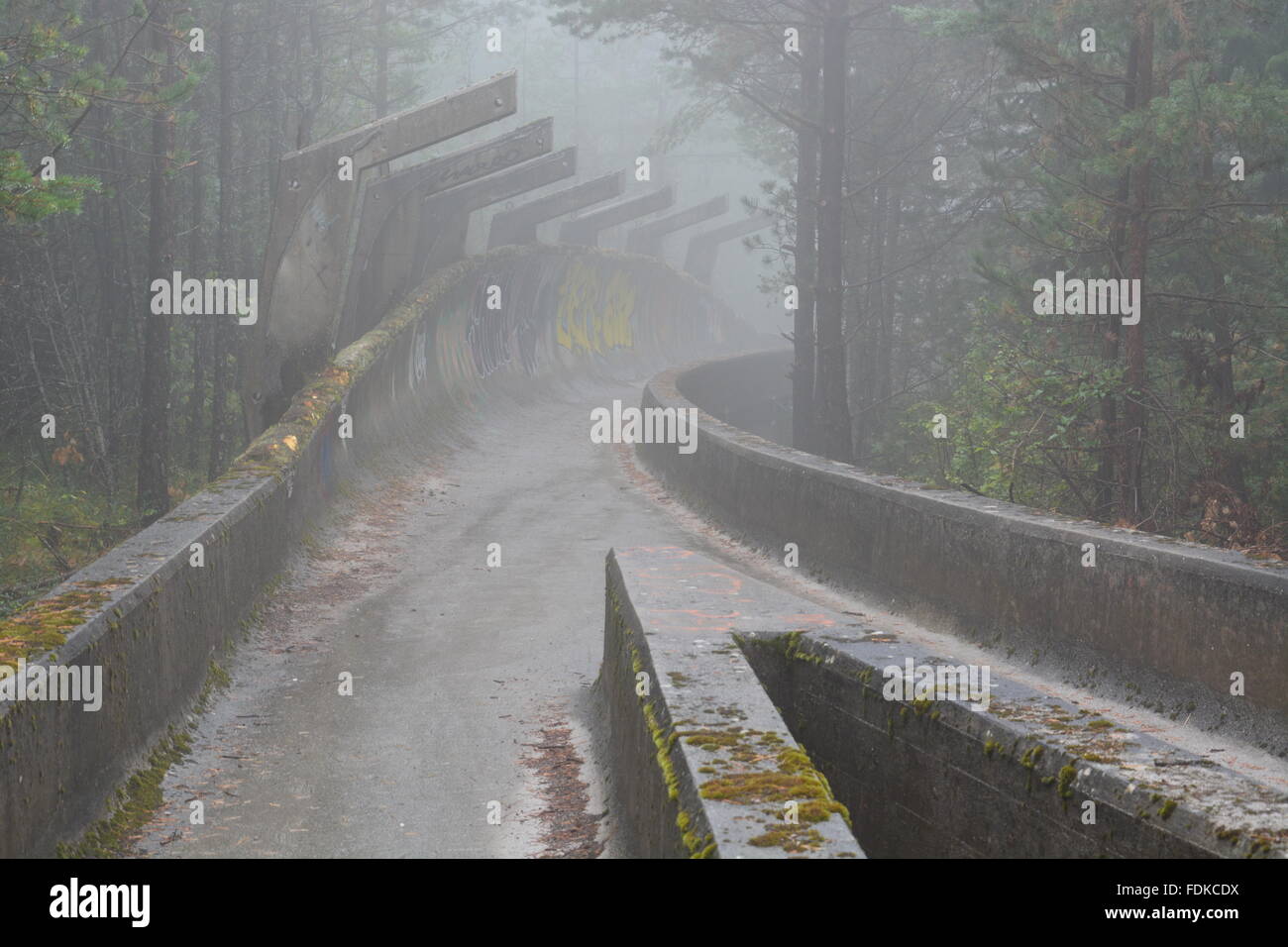 Den Krieg beschädigt Bobbahn der olympischen Winterspiele von 1984 befindet sich in den Bergen oberhalb von Sarajevo aufgegeben. Stockfoto