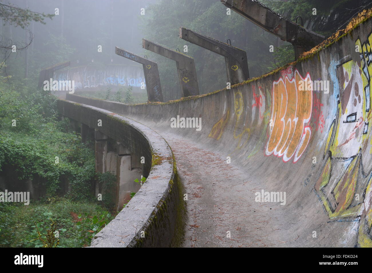 Den Krieg beschädigt Bobbahn der olympischen Winterspiele von 1984 befindet sich in den Bergen oberhalb von Sarajevo aufgegeben. Stockfoto