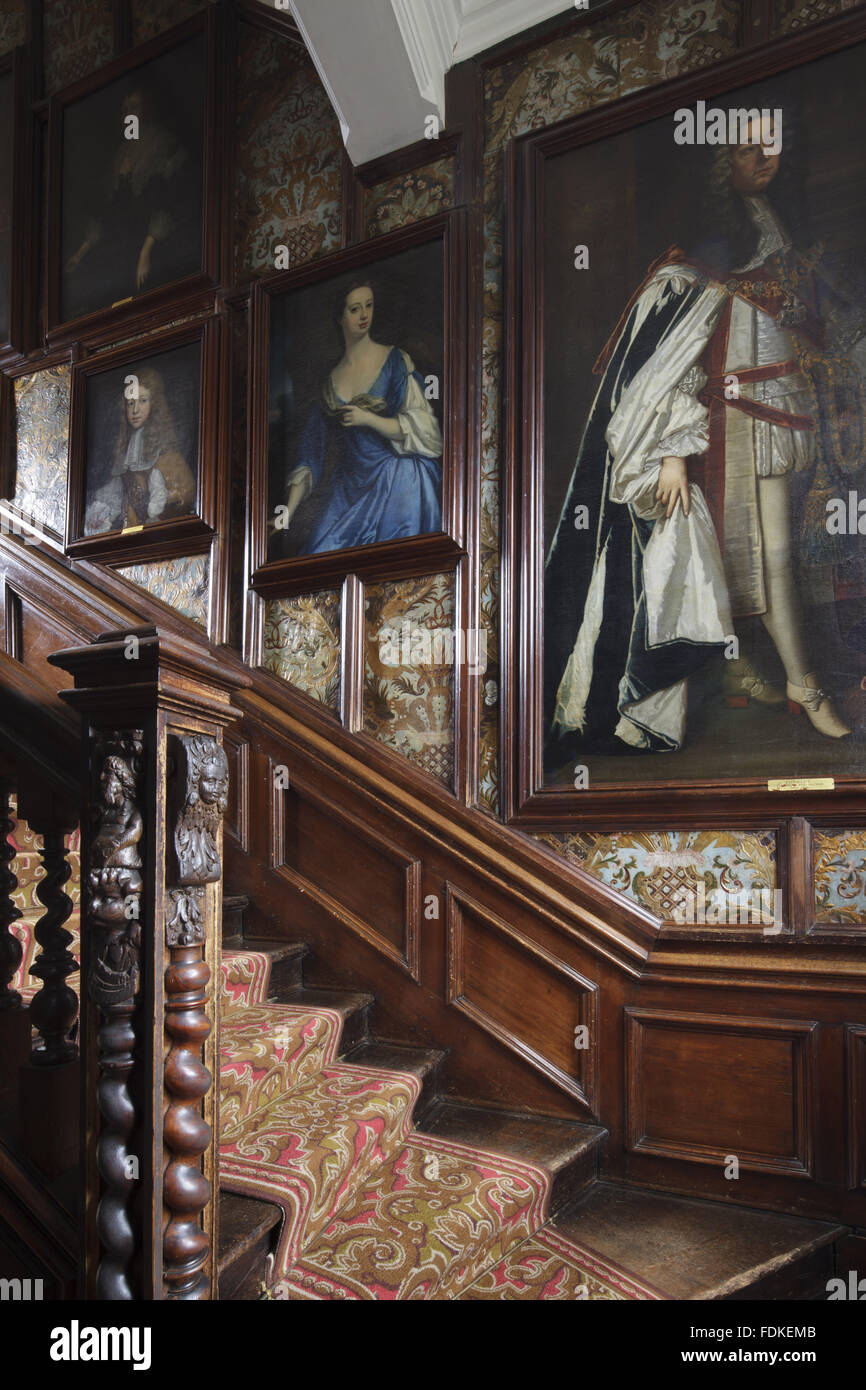 Blick auf die Treppe und Malereien auf der Leder-Tapeten an der Wand des Treppenhauses Nord in Oxburgh Hall, Norfolk. Treppe Teppich ist eine exakte Replik des ursprünglich hier im späten neunzehnten Jahrhundert. Stockfoto