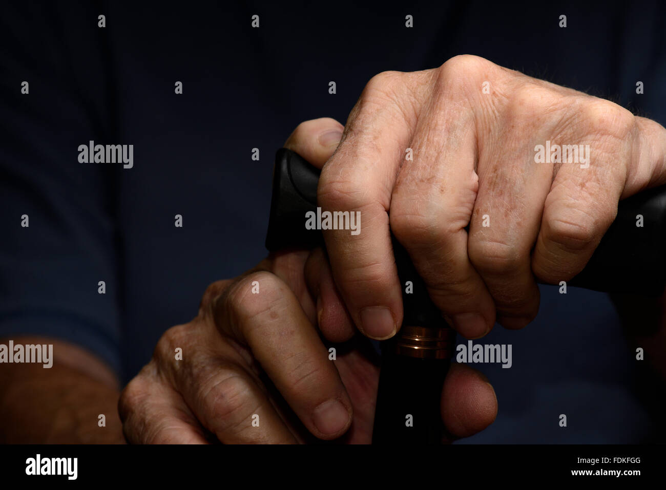 Händen von einer älteren Frau mit chronischen gesundheitlichen und medizinischen Themen greifen einen Gehstock. Stockfoto