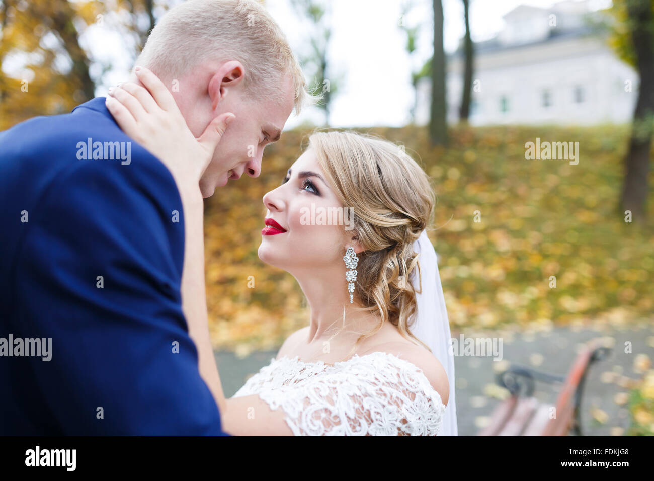 Bräutigam die Braut umarmt vor dem Hintergrund der Blätter im Herbst Stockfoto