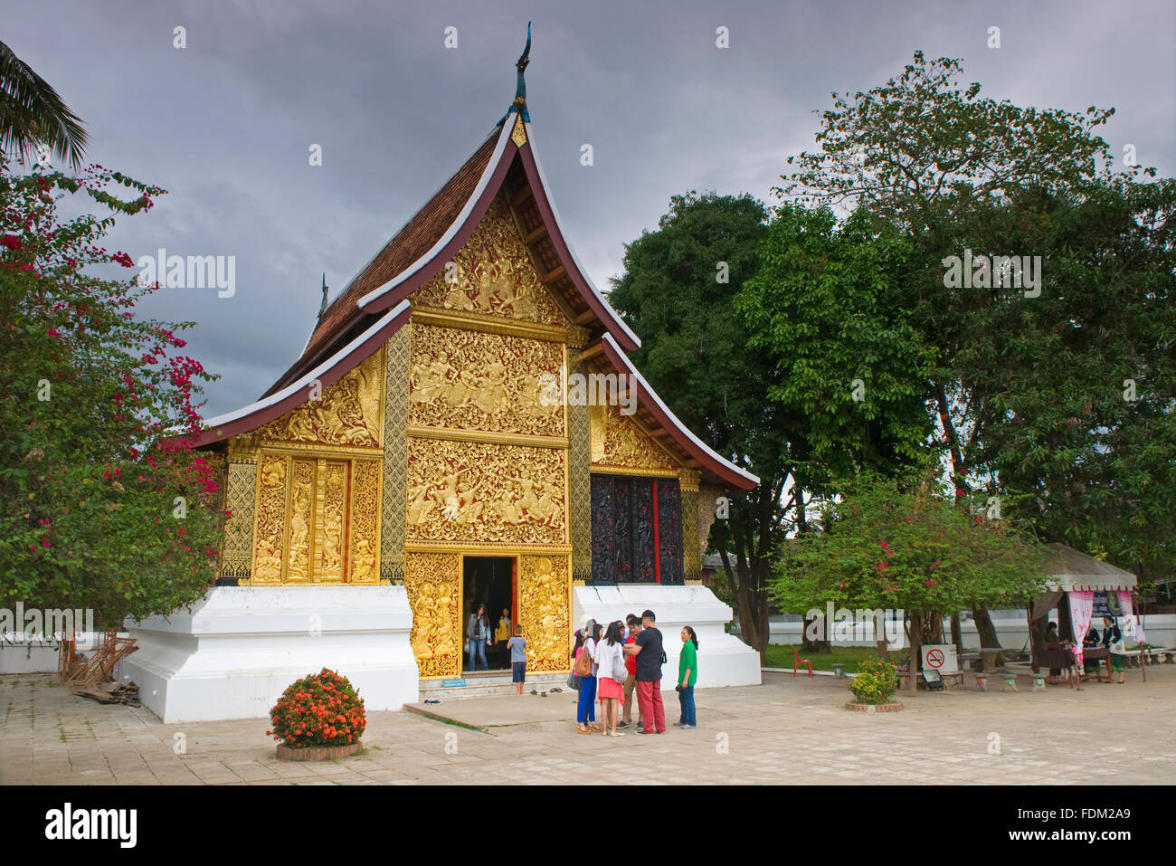 Touristen außerhalb der goldenen Tür in Wat Xieng Thong, Luang Prabang, Laos Stockfoto