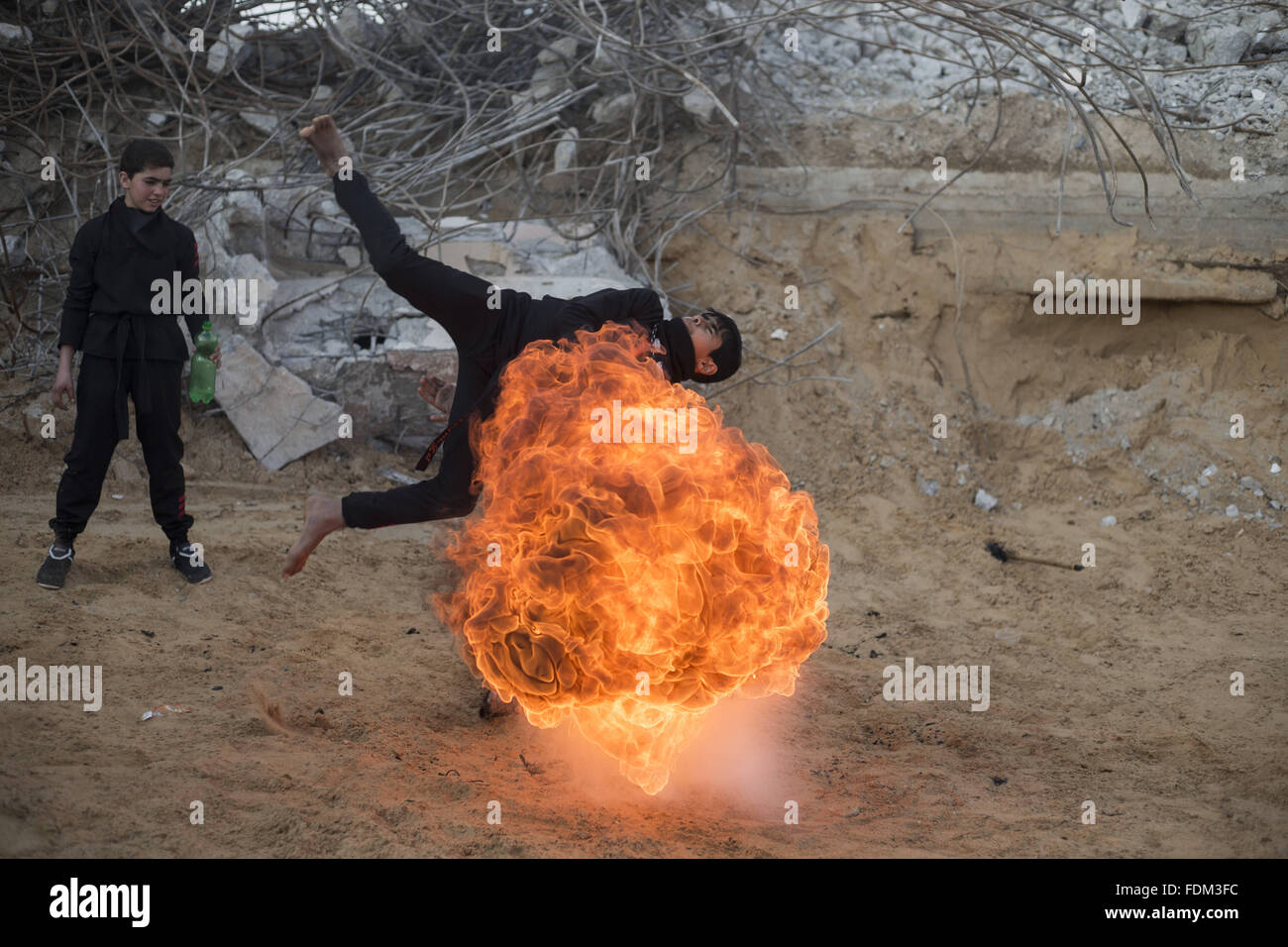 Beit Lahia, Gazastreifen, Palästina. 1. Februar 2016. Palästinensischen Jugendlichen Feuer bläst, wie er Praxis Ninja Martial Arts-Fähigkeiten zwischen den Trümmern der zerstörten Häuser im Al Nada Towers nördlichen Gaza-Streifen, israelische Armee weiter Al Nada Türme in dem letzten Gazakrieg 51 Tagen Beschuss. Bildnachweis: Mahmoud Issa/Quds Net News/ZUMA Draht/Alamy Live-Nachrichten Stockfoto