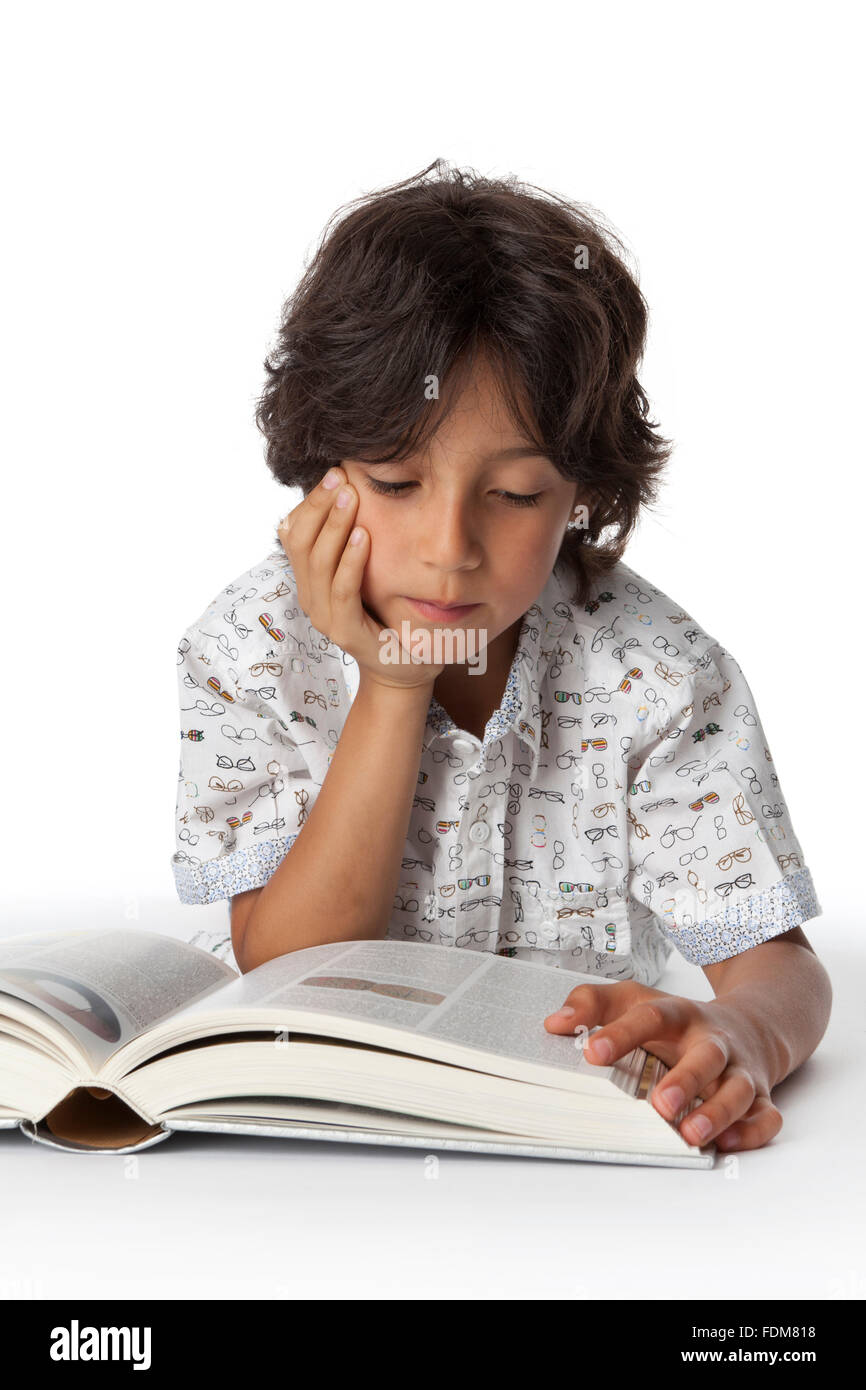 Kleiner Junge liest ein Buch auf weißem Hintergrund Stockfoto