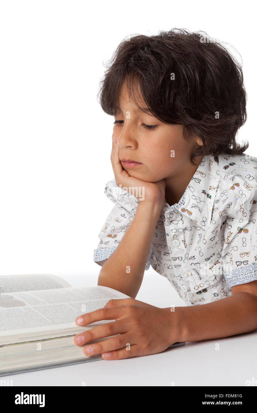 Kleiner Junge liest ein Buch auf weißem Hintergrund Stockfoto