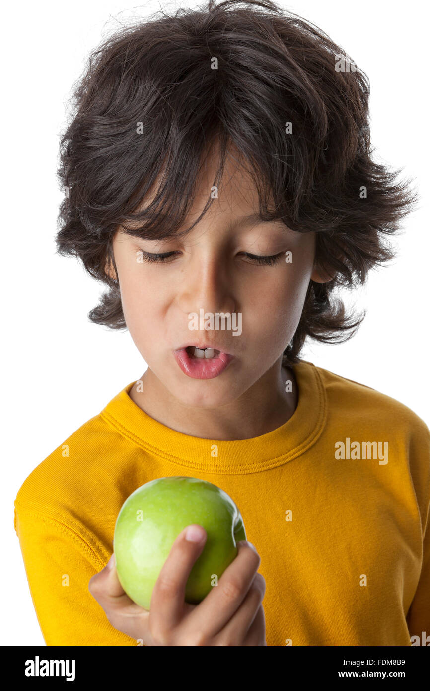 Kleiner Junge, der Blick auf einen grünen Apfel auf weißem Hintergrund Stockfoto
