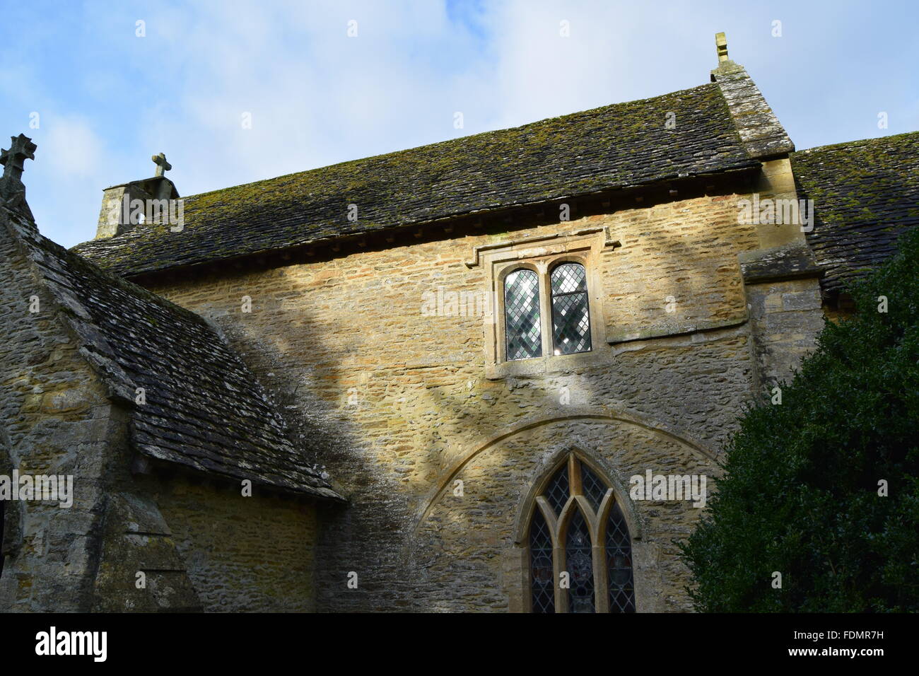 Dies ist ein Bild von eine kleine Dorfkirche mit der Sonne nach unten den alten verschmutzten Fenstern reflektieren. Stockfoto