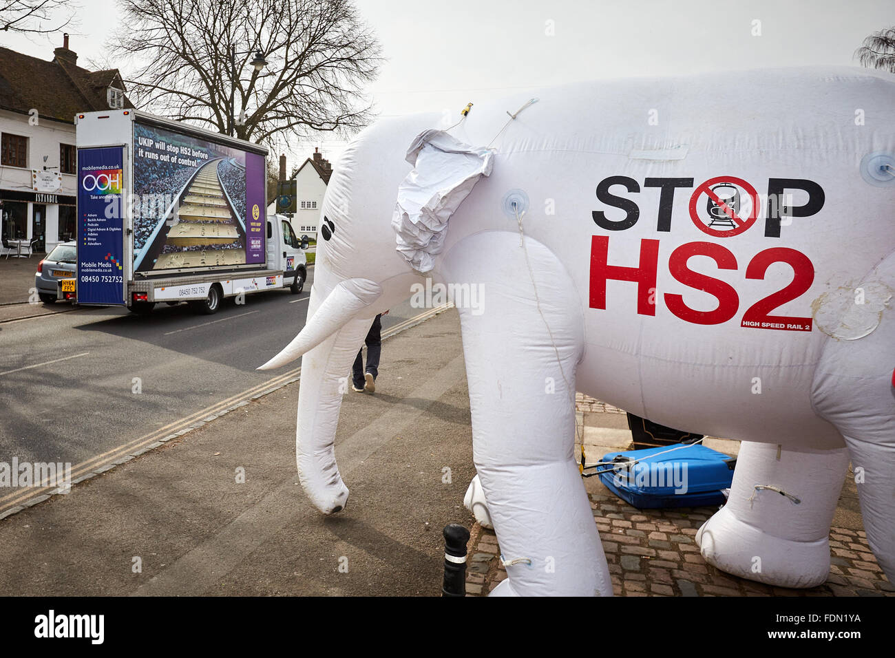 Eine UKIP Anti-HS2-Plakat ist entlang Wendover High Street und vorbei an der Stop HS2 aufblasbare White Elephant getrieben. Stockfoto