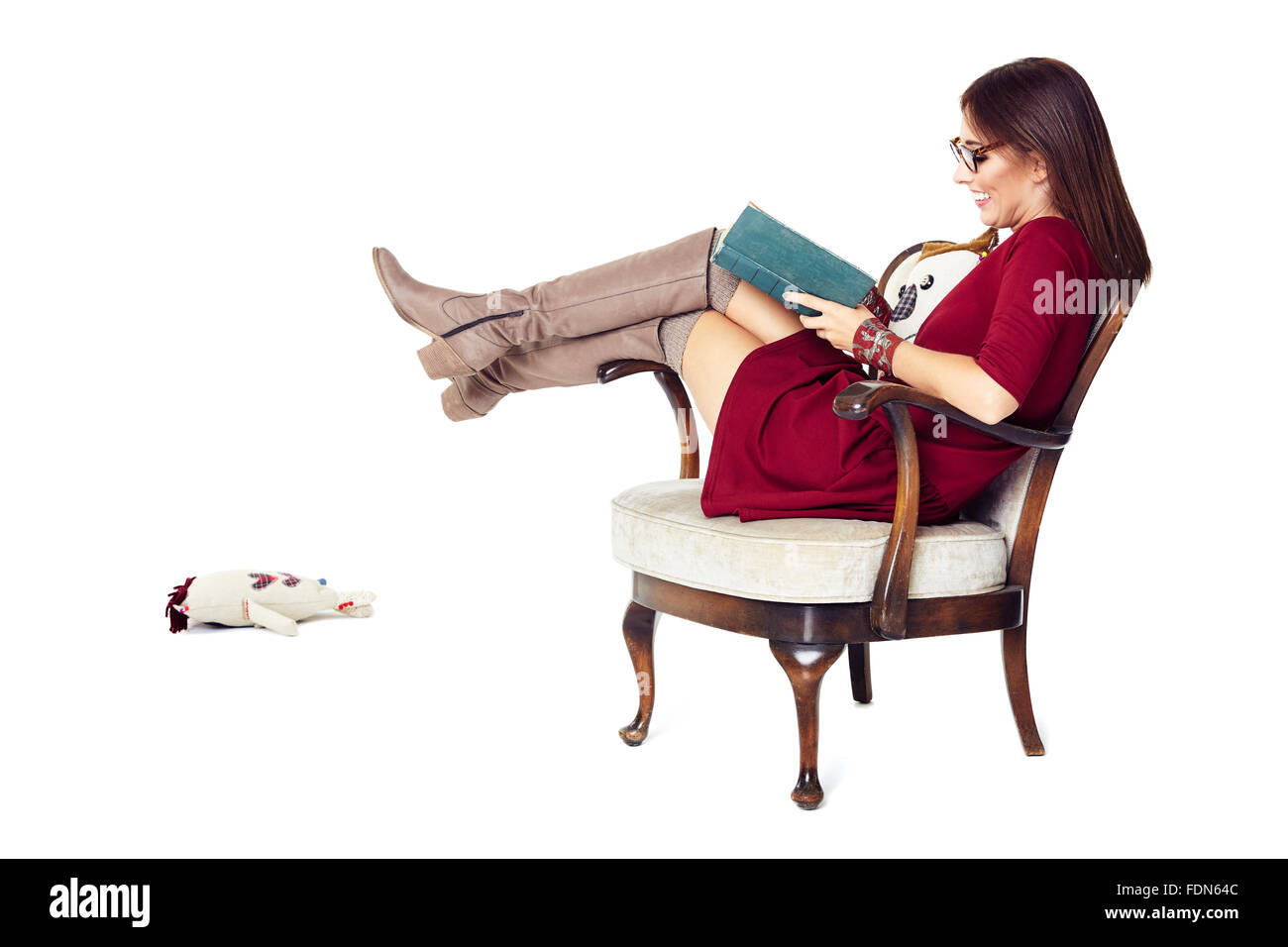 Attraktive Frau, ein Buch zu lesen, während Sie sitzen bequem in einem alten Stuhl. Stockfoto