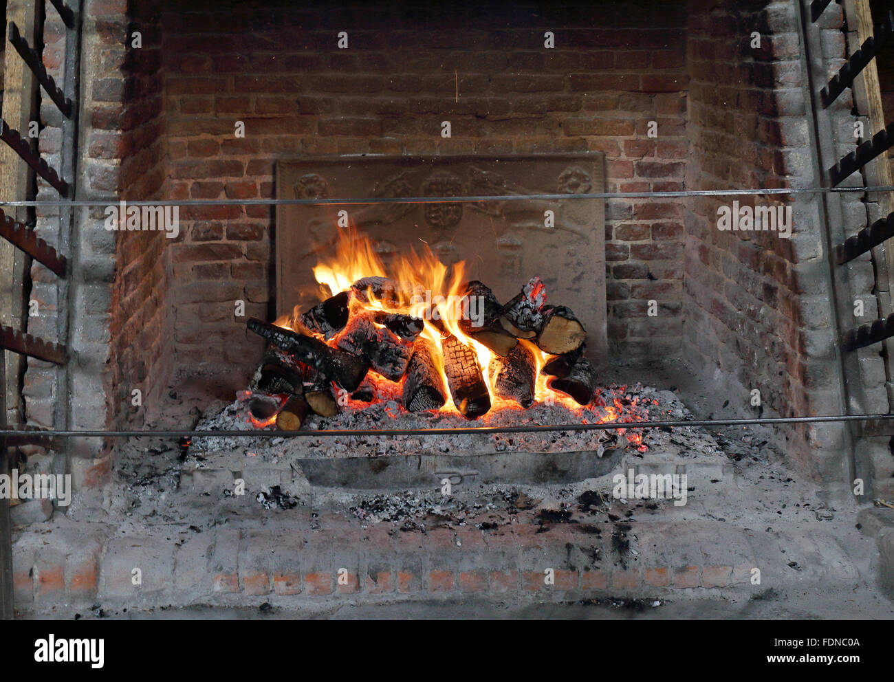 Lodernden Kaminfeuer Log in ein Inglenook Kamin Stockfoto