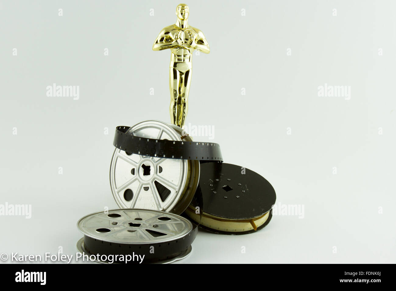 Academy Award Oscar-Statue mit Vintage Film Rollen auf weiß. Stockfoto