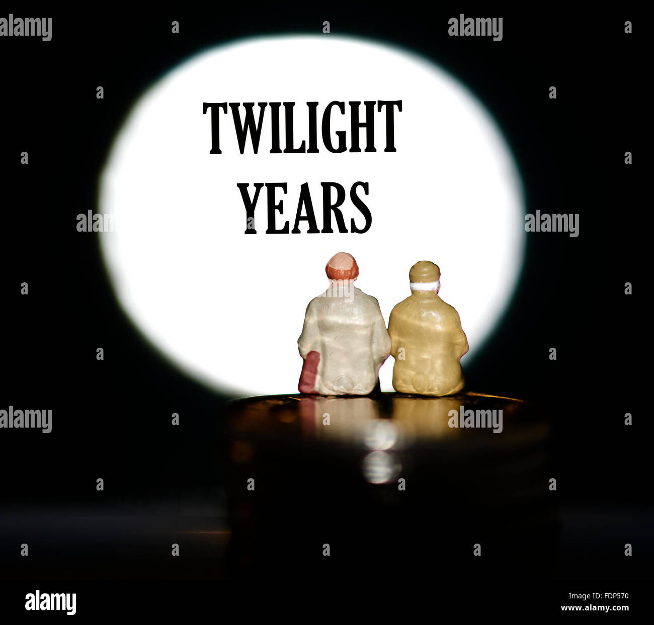 Miniatur Figur Rentner sitzen auf Münzen vor, wird ein Spotlight angezeigt das Wort twilight Jahre Konzept Stockfoto
