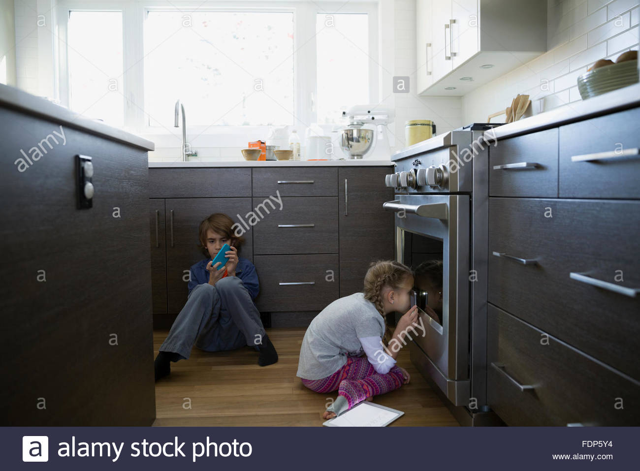 Mädchen peering in Ofen in der Küche Stockfoto