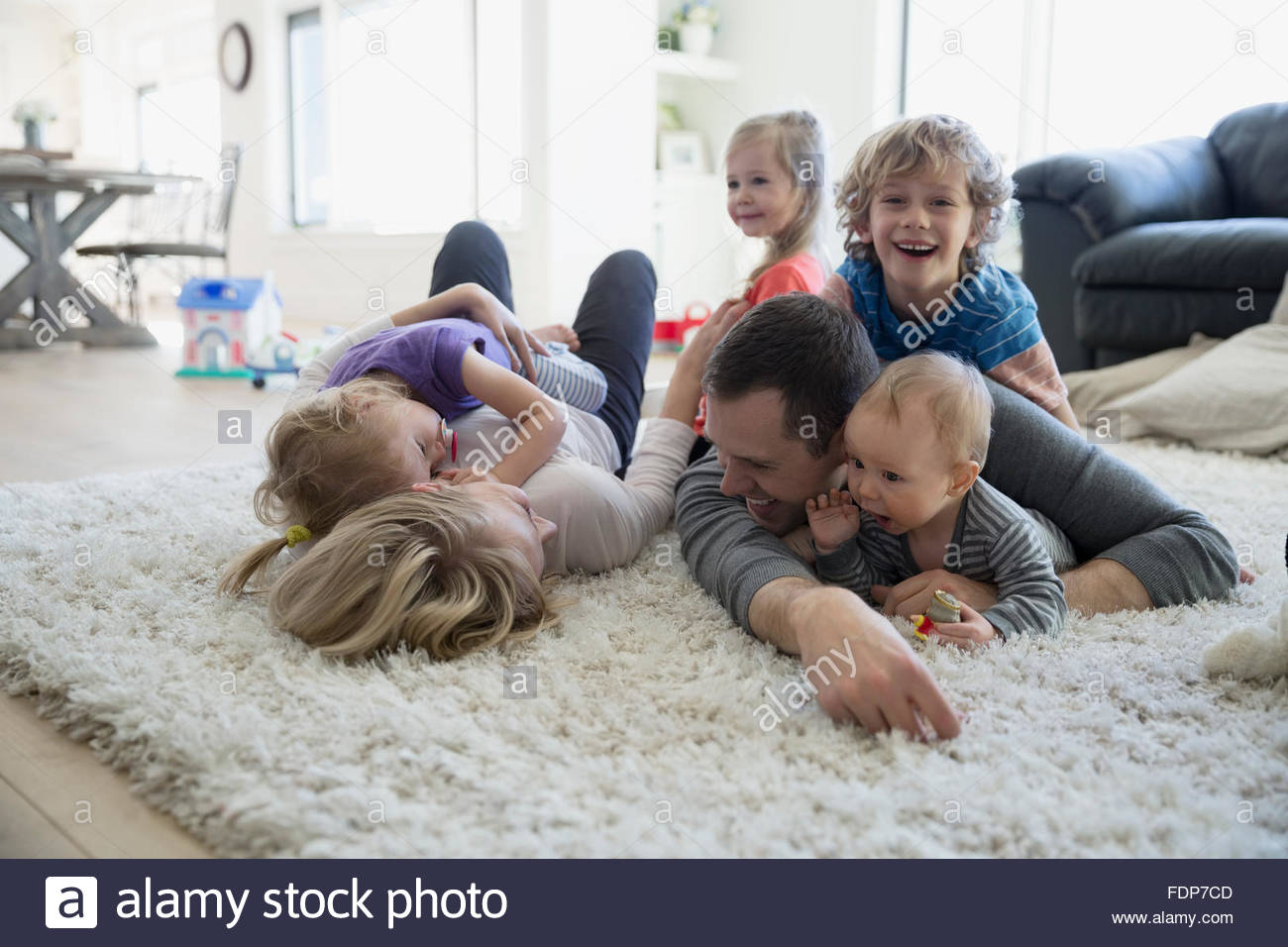 Familie legen und entspannen auf Shag Teppich Stockfoto