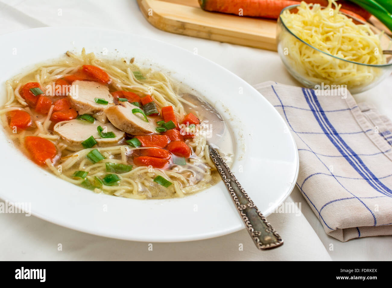 Traditionelle Hühnersuppe mit Fleisch und Karotten und Nudeln auf weißen Tisch Stockfoto