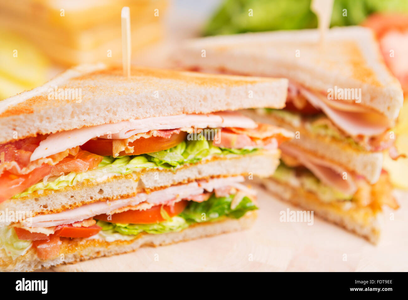 Ein Club-Sandwich auf einem rustikalen Tisch in helles Licht. Stockfoto