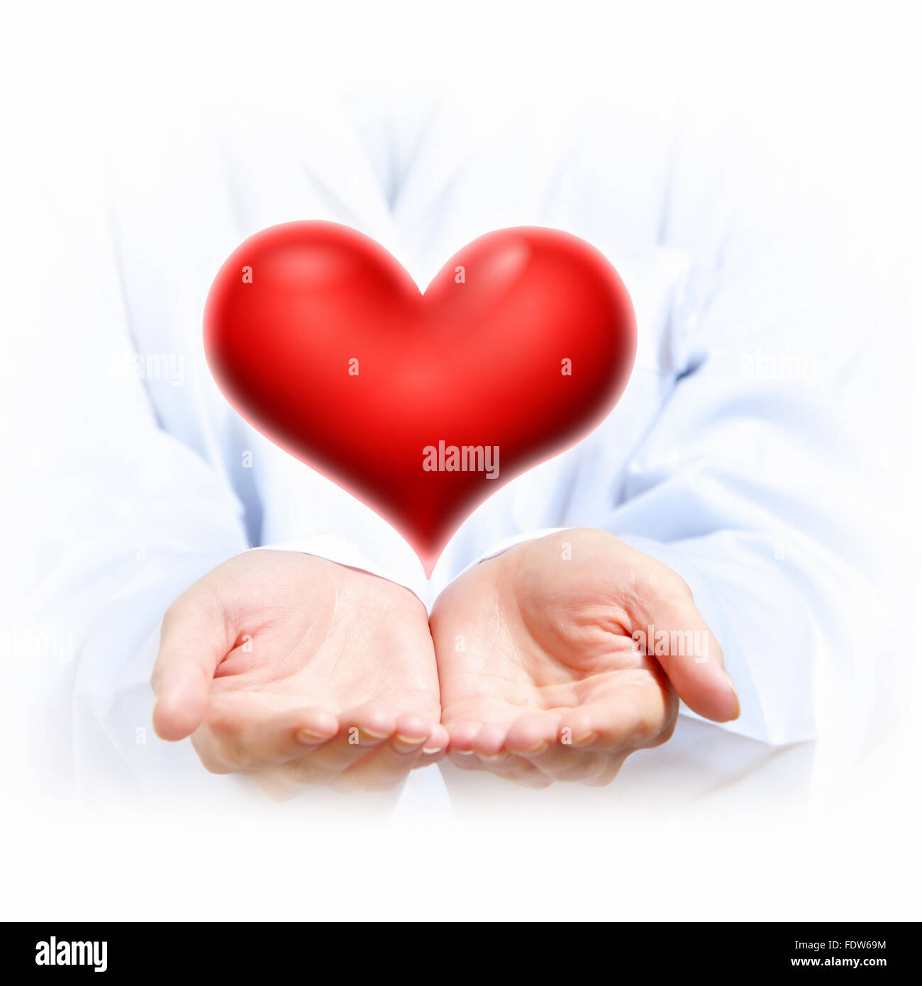 Ein großes rotes Herz in Thehand einer Person Stockfoto