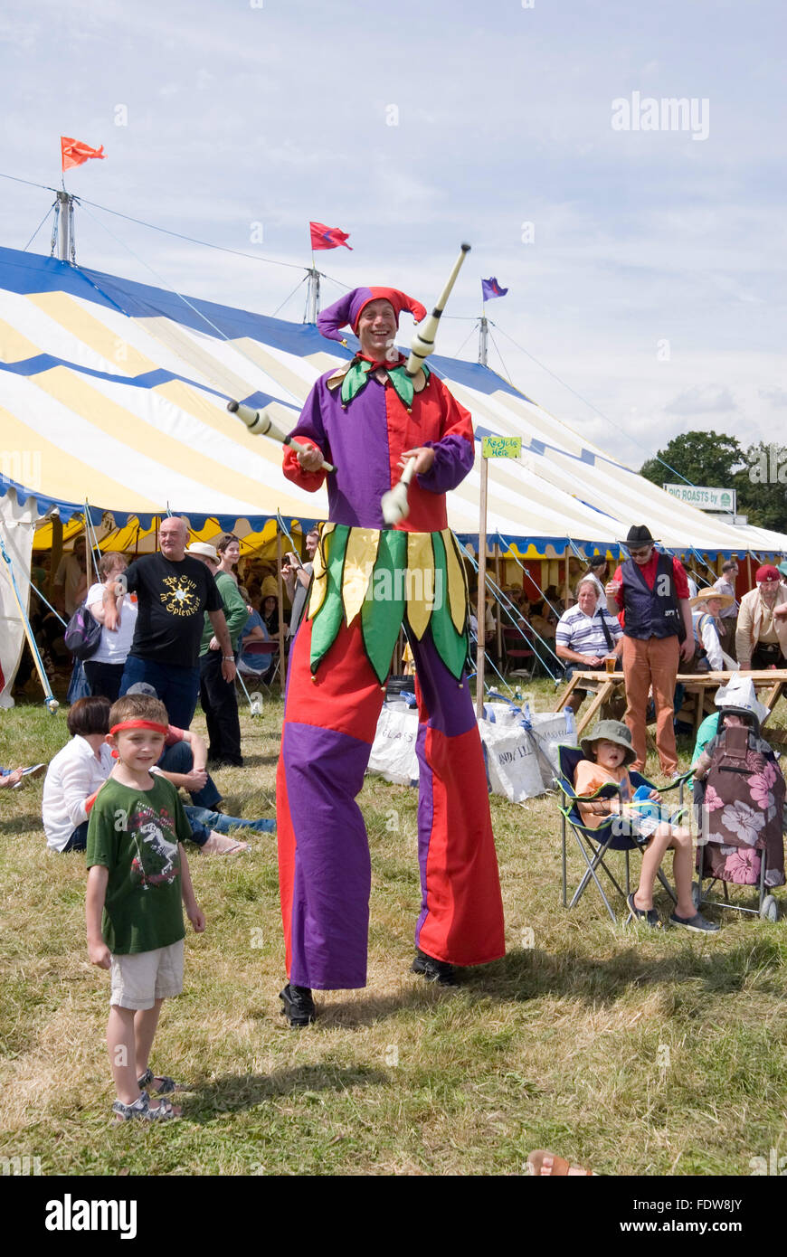 TEWKESBURY, GLOC. UK-11 Juli: Jester auf Stelzen Spaziergänge unter Menge jonglieren am 12. Juli 2014 bei Tewkesbury Mittelalterfest Stockfoto
