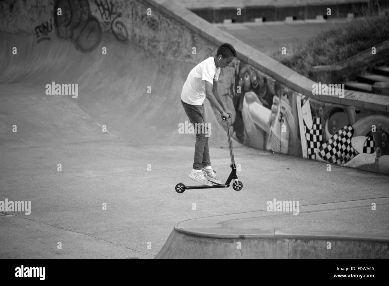 Tricks auf einem Roller im Skateboard-park Stockfoto