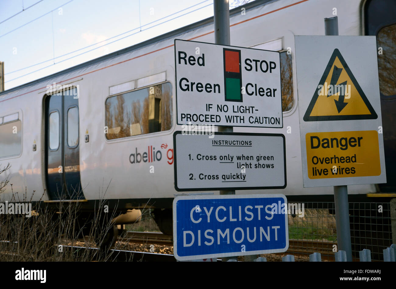 Ein Zug vorbei an einer unbemannten Fußgänger Bahnübergang in der Nähe von Hertford East Station in Hertfordshire Stockfoto