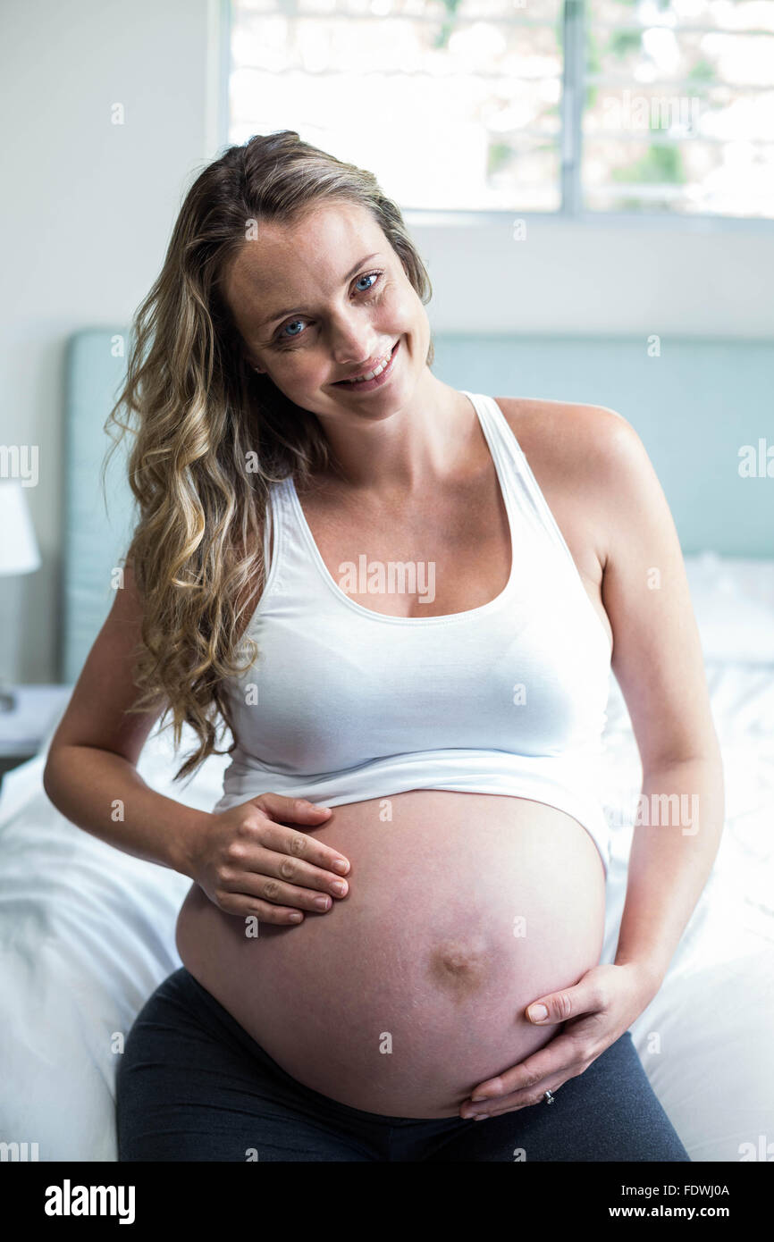 Schwangere Frau massieren ihren Bauch Stockfoto