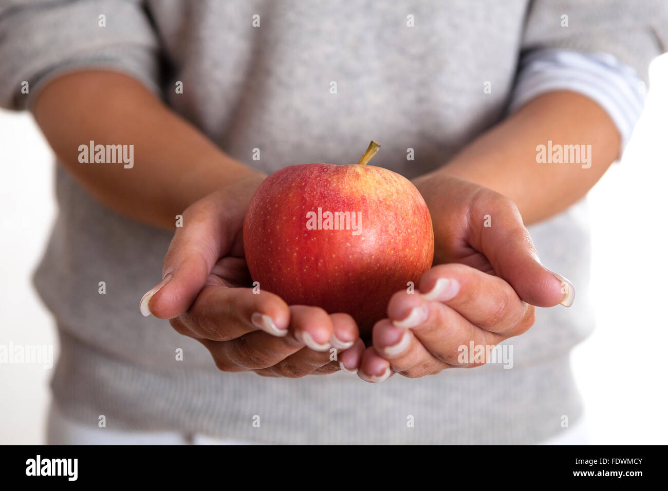 Frau heraus halten, Hände mit einem Apple auf weißem Hintergrund Model Release: Ja. Property Release: Nein. Stockfoto