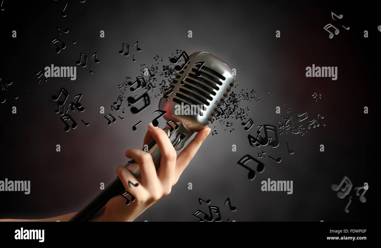 Retro-Mikrofon vor einem dunklen Hintergrund mit Noten Stockfoto