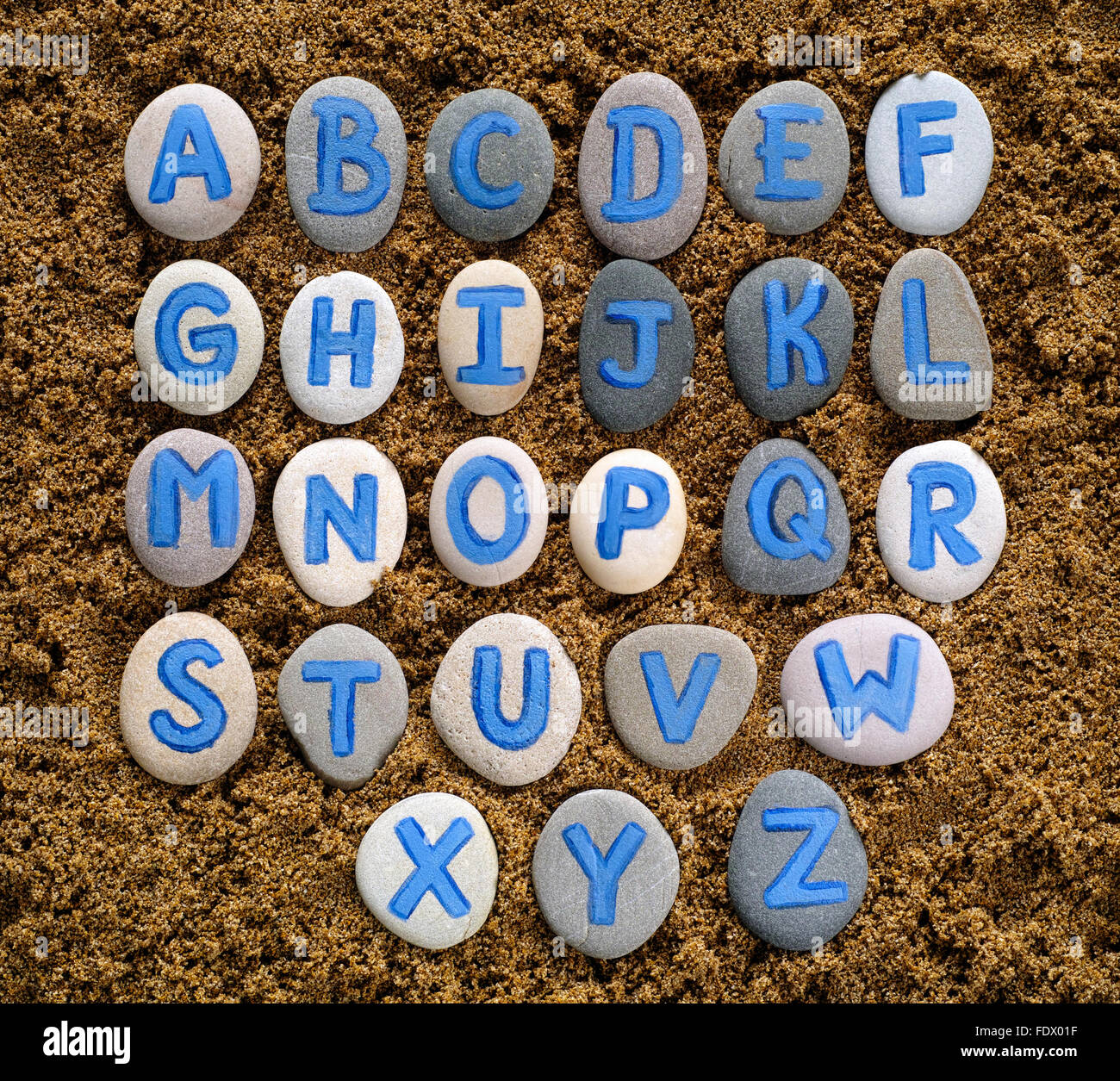 Alphabet Buchstaben auf Steinen Zauber aufs Meeressand gezeichnet. Briefe von mir gezeichnet Stockfoto