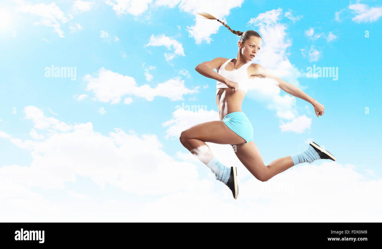 Bild von Sport Mädchen im Sprung bewölkten Hintergrund Stockfoto