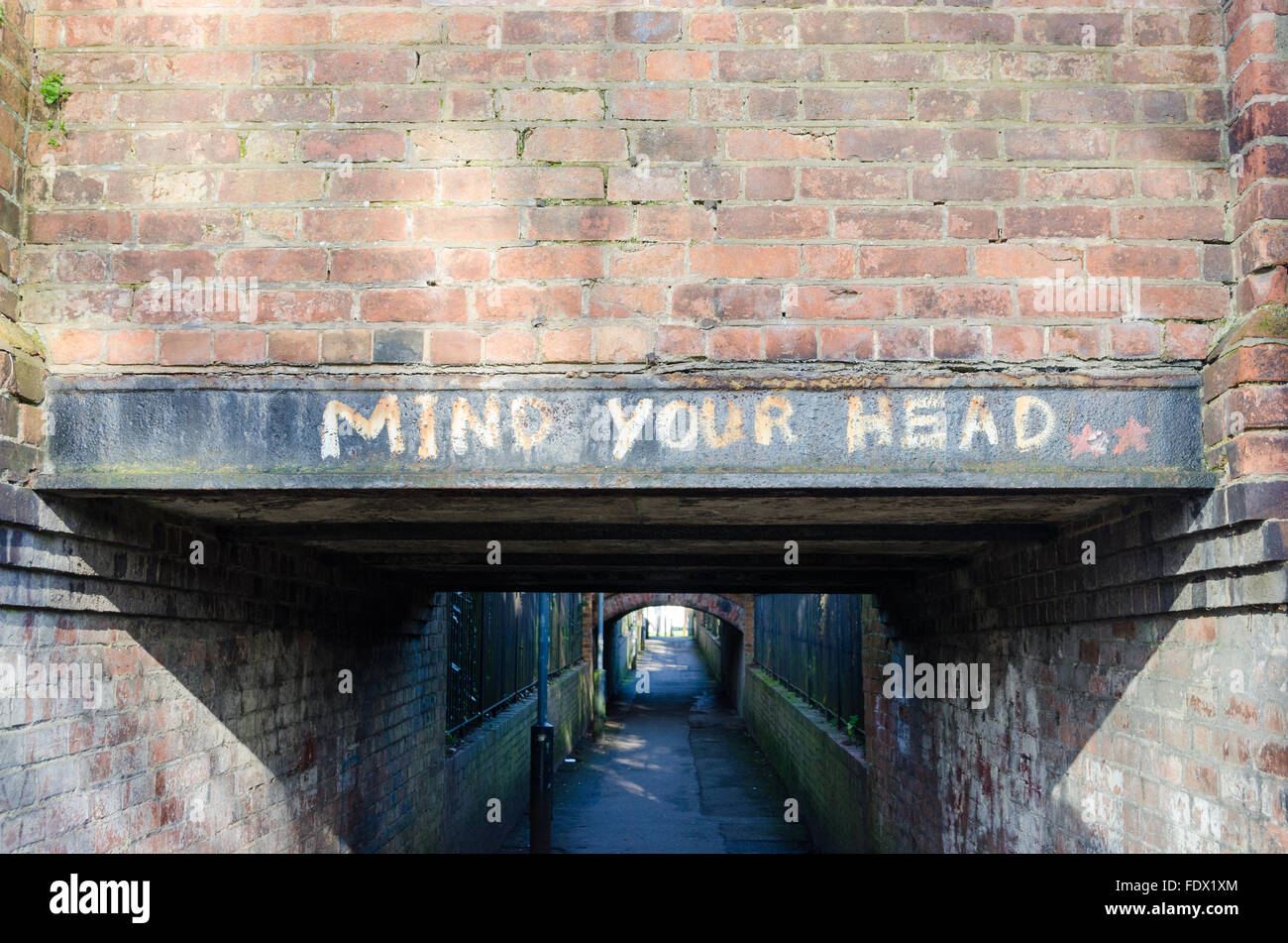 "Ihr Kopf dagegen" über einen niedrigen Tunnel gemalt Stockfoto