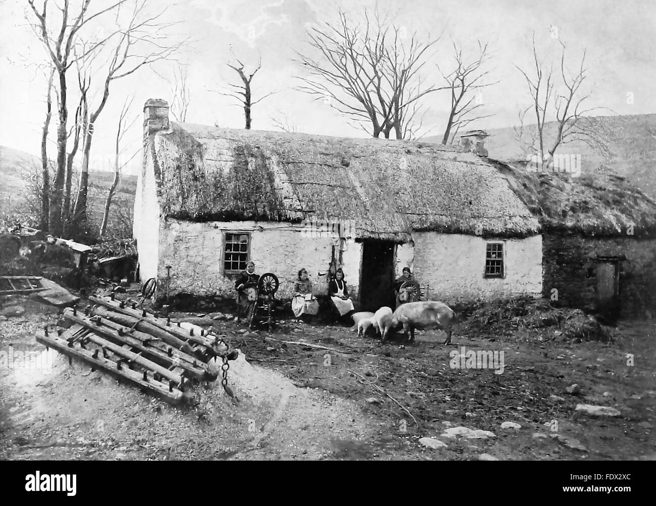 Haus in der Nähe von PORTRUSH, Nordirland, um 1890. Hinweis spinnendes Rad neben die Dame auf der linken Seite Stockfoto