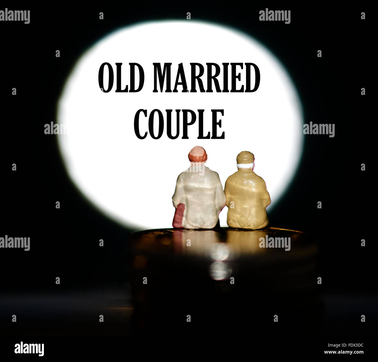 Miniatur Figur Rentner sitzen auf Münzen vor einen Scheinwerfer Ehepaar mit den Worten alt Stockfoto