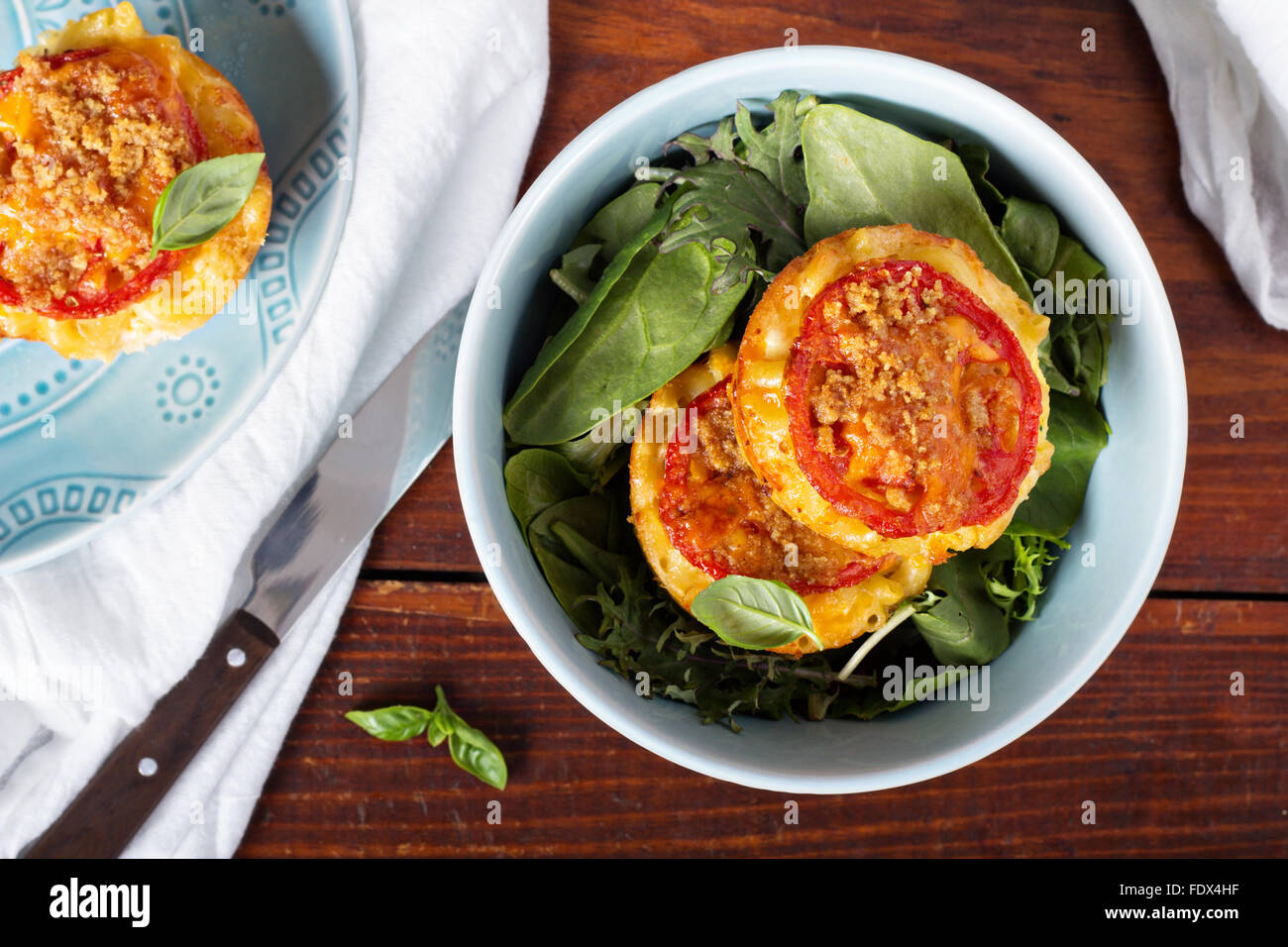 Makkaroni und Käse in Muffinformen mit Tomaten Stockfoto